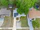 Overhead view of a single-Gathering home with solar panels, a driveway, and mature landscaping at 6031 W Ridgewood Ave, Orlando, FL 32835