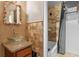 Bathroom featuring a unique vanity, a decorative mirror, and a shower/tub combo, designed for relaxation and comfort at 6031 W Ridgewood Ave, Orlando, FL 32835