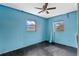 The light blue bedroom offers natural light from two windows and a blank canvas for customization at 6031 W Ridgewood Ave, Orlando, FL 32835