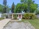 Charming single-story home featuring a red front door and a well-maintained, rock landscaped front yard at 6031 W Ridgewood Ave, Orlando, FL 32835