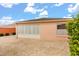 Rear exterior featuring a paved patio area, sunroom, and tasteful landscaping at 613 Nuevo Leon Ln, The Villages, FL 32159