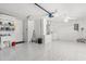 Spacious garage with sink, laundry area, epoxy floor, and ample storage shelving at 613 Nuevo Leon Ln, The Villages, FL 32159