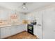 Well-lit kitchen featuring white cabinetry, wood flooring, and modern appliances at 613 Nuevo Leon Ln, The Villages, FL 32159