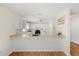 Open kitchen with bar seating, white cabinetry and hardwood flooring and modern appliances at 613 Nuevo Leon Ln, The Villages, FL 32159