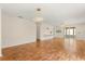 Bright living room with wood floors, slider door to porch, and contemporary lighting at 613 Nuevo Leon Ln, The Villages, FL 32159