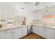 Bright kitchen boasts white cabinets, sleek countertops, stainless steel dishwasher, and hardwood floors at 613 Nuevo Leon Ln, The Villages, FL 32159