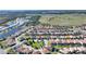 Aerial view of a sprawling community with a red pin marking the house location near a lake and community amenities at 7012 Oakwood St, Davenport, FL 33837