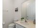 Simple bathroom featuring a toilet, sink, mirror, and towel rack; clean and functional space at 7012 Oakwood St, Davenport, FL 33837