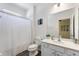 Bright bathroom featuring a shower-tub combo, light-colored vanity, and gray wood-look flooring at 7012 Oakwood St, Davenport, FL 33837