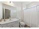 Bright bathroom featuring a shower-tub combo, light-colored vanity, and gray wood-look flooring at 7012 Oakwood St, Davenport, FL 33837