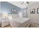 Well-lit bedroom featuring a large bed, light blue accent wall, night stands, and modern artwork at 7012 Oakwood St, Davenport, FL 33837