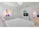 Bright bedroom featuring a modern white bed and view into the bathroom at 7012 Oakwood St, Davenport, FL 33837