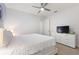 Bright bedroom showcasing a large bed, ceiling fan, and a dresser with a mounted television at 7012 Oakwood St, Davenport, FL 33837