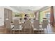 Open-concept dining area with a glass table and view to living room and outdoor patio at 7012 Oakwood St, Davenport, FL 33837
