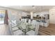Elegant dining area with a large glass table and white chairs, connected to the kitchen at 7012 Oakwood St, Davenport, FL 33837