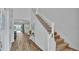 Bright entryway featuring wood flooring, a staircase, and white walls at 7012 Oakwood St, Davenport, FL 33837