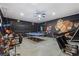Spacious game room featuring fun artwork, game systems, a ping pong table and comfortable seating at 7012 Oakwood St, Davenport, FL 33837
