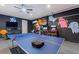 Vibrant game room showcases a ping pong table, video game systems, and fun Pac-Personal themed decorations at 7012 Oakwood St, Davenport, FL 33837