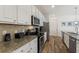 Close-up of well-equipped kitchen featuring granite countertops and stainless steel appliances at 7012 Oakwood St, Davenport, FL 33837
