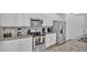 Bright kitchen features white cabinets, stainless steel appliances, and granite countertops at 7012 Oakwood St, Davenport, FL 33837