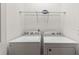 Laundry room with a side by side washer and dryer with overhead wire shelf at 7012 Oakwood St, Davenport, FL 33837