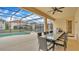 Lovely screened-in pool and patio area with dining table and grill, perfect for outdoor entertaining at 7012 Oakwood St, Davenport, FL 33837