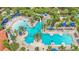 Aerial view of a community pool featuring palm trees, lounge chairs, and blue umbrellas at 7012 Oakwood St, Davenport, FL 33837