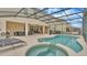Beautiful screened-in pool and spa area with outdoor seating, perfect for relaxing and entertaining at 7012 Oakwood St, Davenport, FL 33837