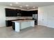 Bright, open-concept kitchen with dark cabinetry, stainless steel appliances, and a center island at 725 Ginger Dr, Haines City, FL 33844