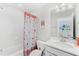 A cozy bathroom space with a tub-shower combination and a marble-style countertop sink at 7633 Agrigento St, Clermont, FL 34714