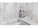 White bathroom with shower/tub combo, white countertop, modern fixtures, and natural light at 7633 Agrigento St, Clermont, FL 34714