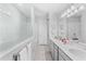 Spacious bathroom featuring double vanity, quartz countertops, walk-in shower with glass enclosure, and white cabinets at 7633 Agrigento St, Clermont, FL 34714