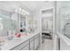 Bright bathroom with double vanity, undermount sinks, white countertops, and shower with glass enclosure at 7633 Agrigento St, Clermont, FL 34714