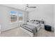 Modern bedroom with two large windows, white headboard and bedframe, and grey bedding at 7633 Agrigento St, Clermont, FL 34714