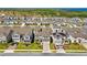 Aerial view of a well-planned community with manicured lawns and modern homes near a greenbelt and blue lake in the distance at 7633 Agrigento St, Clermont, FL 34714