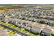 Aerial view of homes in a planned community, some with pools, and solar panels, surrounded by lush landscaping at 7633 Agrigento St, Clermont, FL 34714