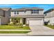 Charming two-story home featuring a manicured lawn, a two-car garage, and tasteful landscaping at 7633 Agrigento St, Clermont, FL 34714