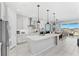 Bright, spacious kitchen featuring white cabinets, stainless steel appliances, and an island, perfect for cooking and entertaining at 7633 Agrigento St, Clermont, FL 34714