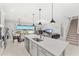Open kitchen featuring a large island with stainless sink and view to dining and living spaces at 7633 Agrigento St, Clermont, FL 34714
