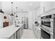 Modern kitchen featuring white cabinets, stainless steel appliances, a center island, and stylish pendant lighting at 7633 Agrigento St, Clermont, FL 34714