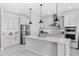 Modern kitchen with a large island, stainless steel appliances, white cabinets, and pendant lighting at 7633 Agrigento St, Clermont, FL 34714