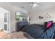 The home's bedroom includes a large tv, modern decor, and wood-look floors at 861 Grazie Loop, Davenport, FL 33837