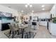 Bright dining area with open layout, featuring a modern dining table, a patterned rug, and seamless access to the kitchen at 861 Grazie Loop, Davenport, FL 33837