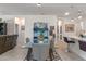 Open-concept dining area with a glass-top table, a modern rug, an aquarium, and kitchen barstool seating in the background at 861 Grazie Loop, Davenport, FL 33837