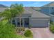 Beautiful single-story home featuring a brick-paved driveway, two-car garage, and lush landscaping, seen from an aerial perspective at 861 Grazie Loop, Davenport, FL 33837