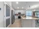 Bright kitchen with white cabinets, a stainless steel refrigerator, an island, and tile floors in an open-concept layout at 861 Grazie Loop, Davenport, FL 33837