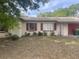 Charming single-story home with a red-trimmed roof, attached garage, and small front yard at 904 Hickory Ave, Fruitland Park, FL 34731