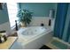 Bathroom with a white corner soaking tub, tile surround, and a bright window at 908 Hilly Bend Dr, Apopka, FL 32712