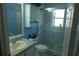 Bright blue bathroom featuring a glass-door shower, vanity, and toilet with storage at 908 Hilly Bend Dr, Apopka, FL 32712