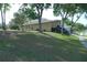 A view of the home from the side yard showing mature trees, lush lawn and driveway parking at 908 Hilly Bend Dr, Apopka, FL 32712